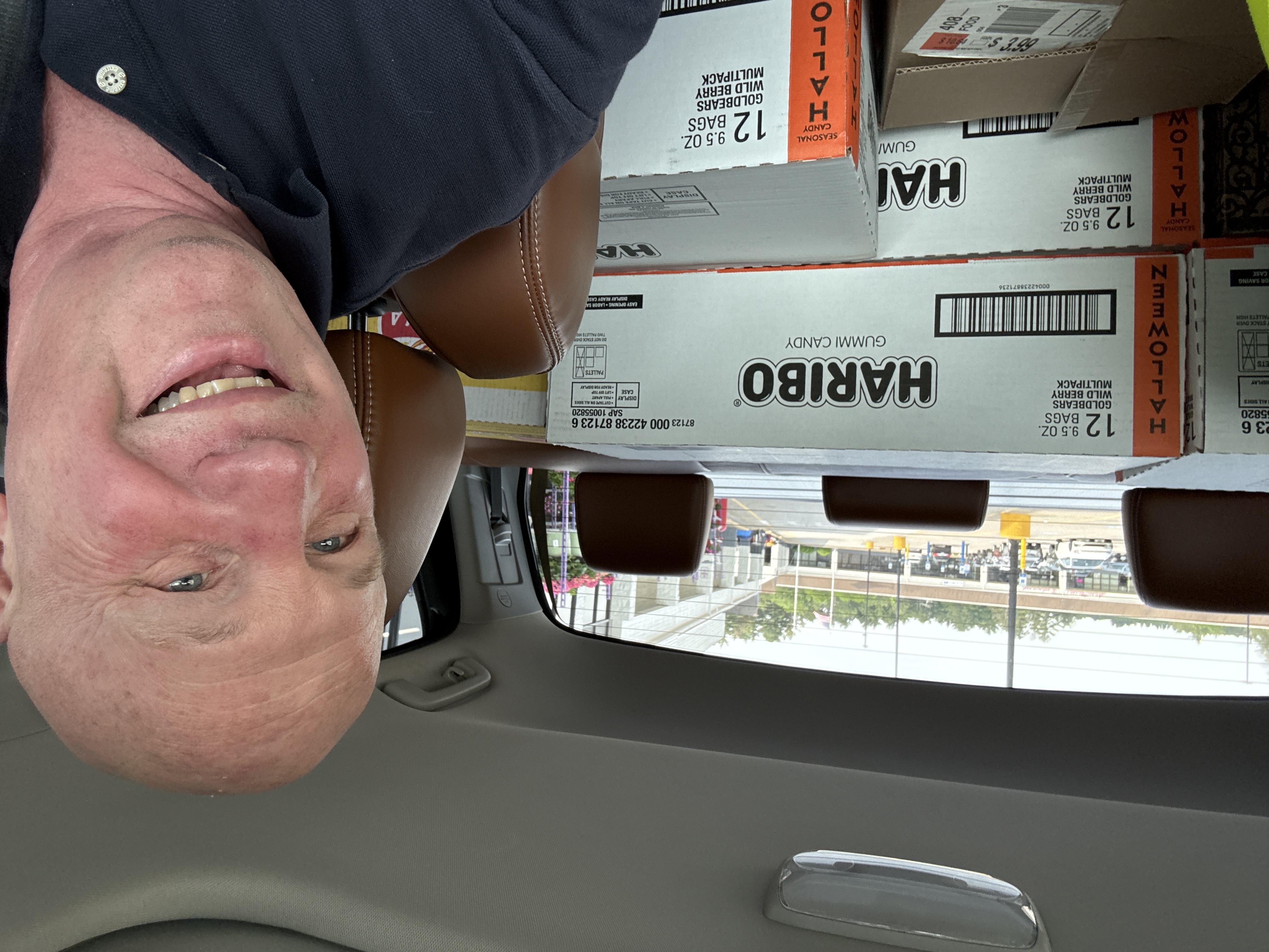 Chuck Tyls smiling inside his truck with boxes of donated food loaded behind him